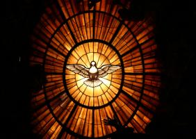 Photo of stained glass window with a dove in the center of it