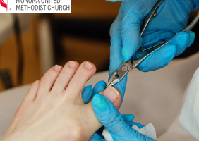 Photo of a blue-gloved hand clipping toenails on a foot
