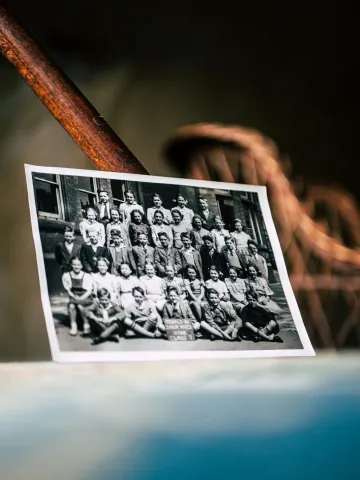 black and white photo of children in rows propped up against a wall